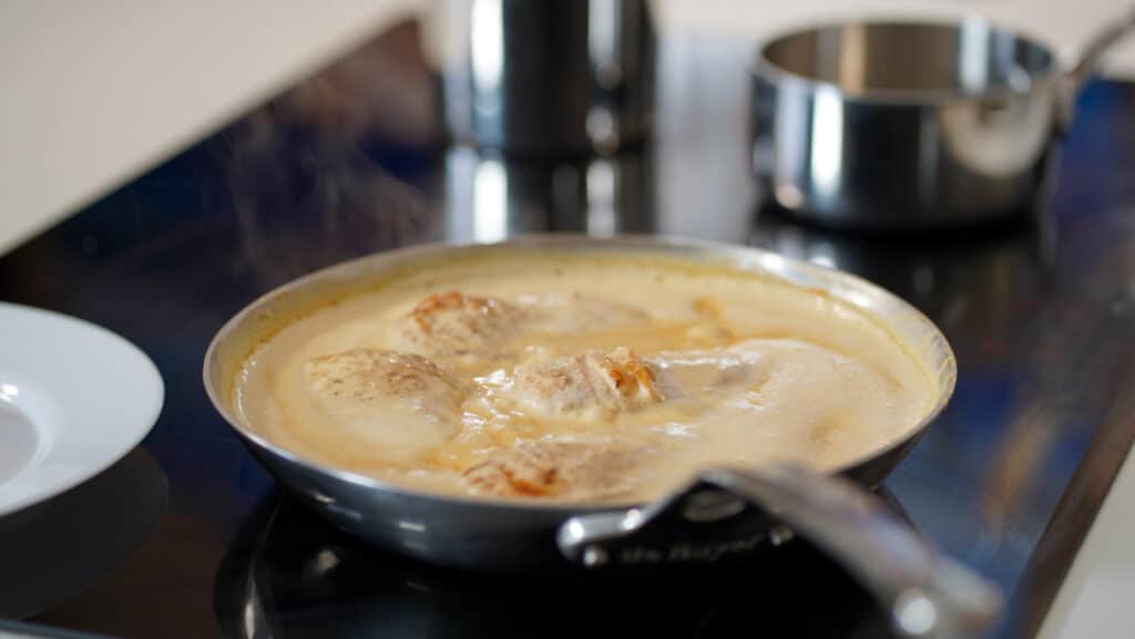 chicken cooking in alfredo sauce