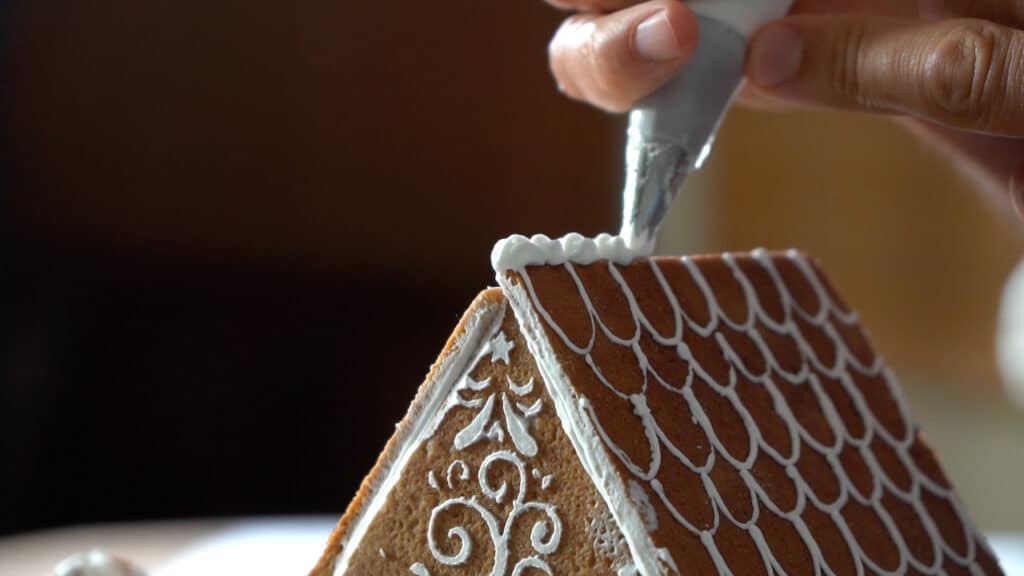 pipping royal icing on gingerbread
