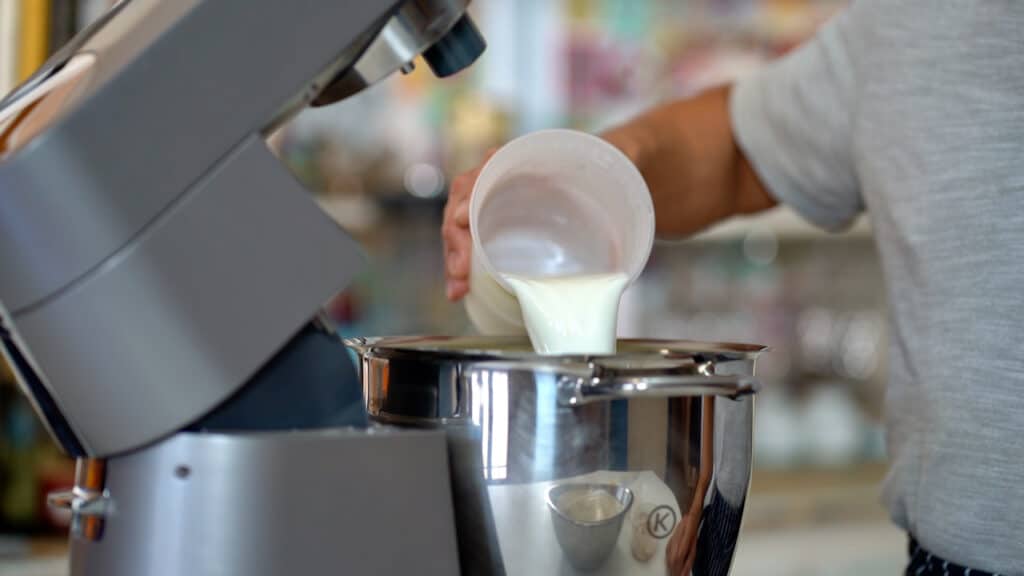 pouring liquid in mixing bowl for croissant dough