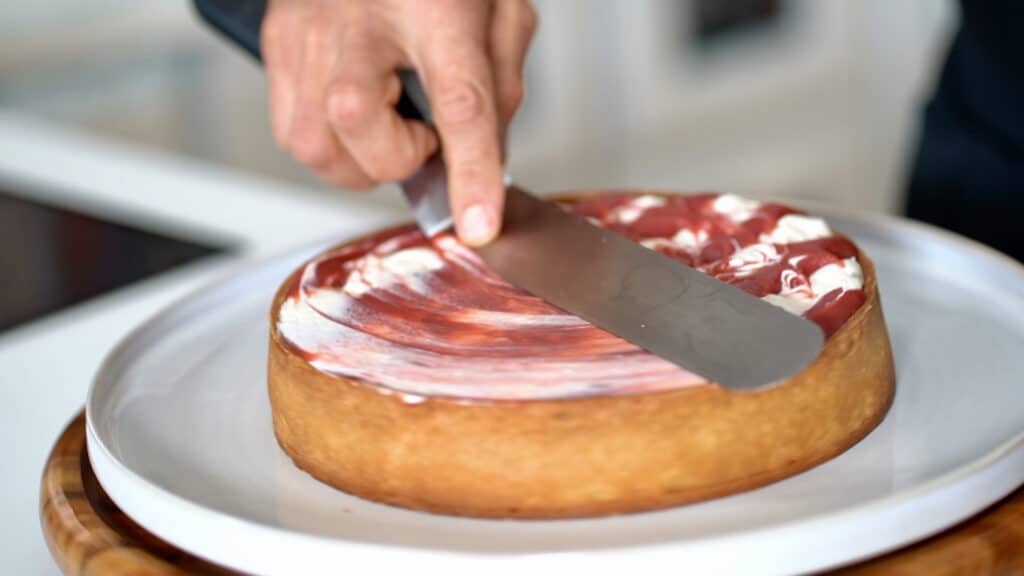 smooth out grape tart with an offset spatula