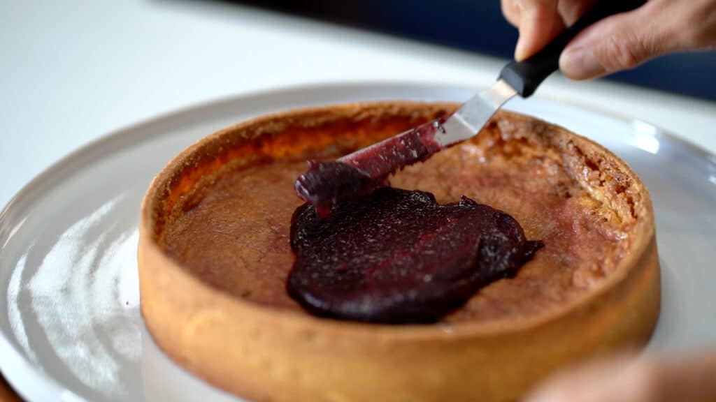 spreading cassis marmalade in tart